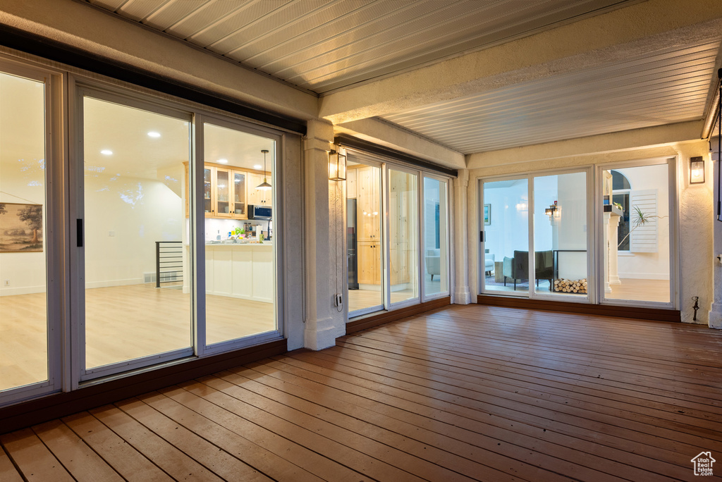 Unfurnished sunroom with hardwood / wood-style flooring and a deck