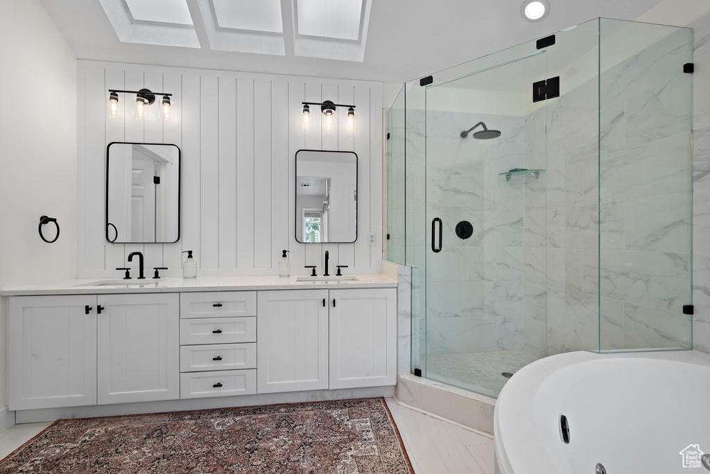 Bathroom with a marble finish shower, double vanity, and a whirlpool tub