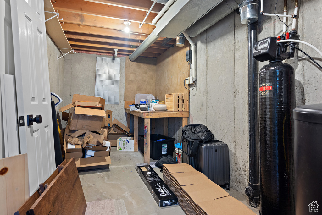 Unfinished basement featuring a water softener system