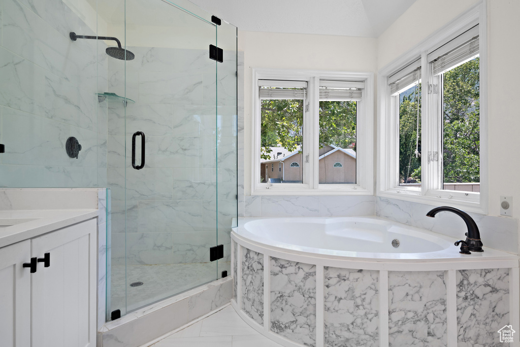 Full bath featuring a marble finish shower, a bath, vanity, and marble finish flooring