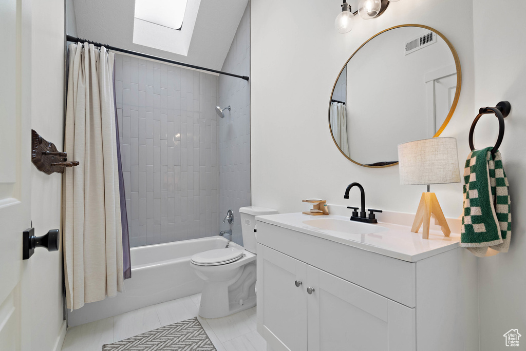 Full bath featuring vanity, shower / bath combo with shower curtain, and tile patterned floors