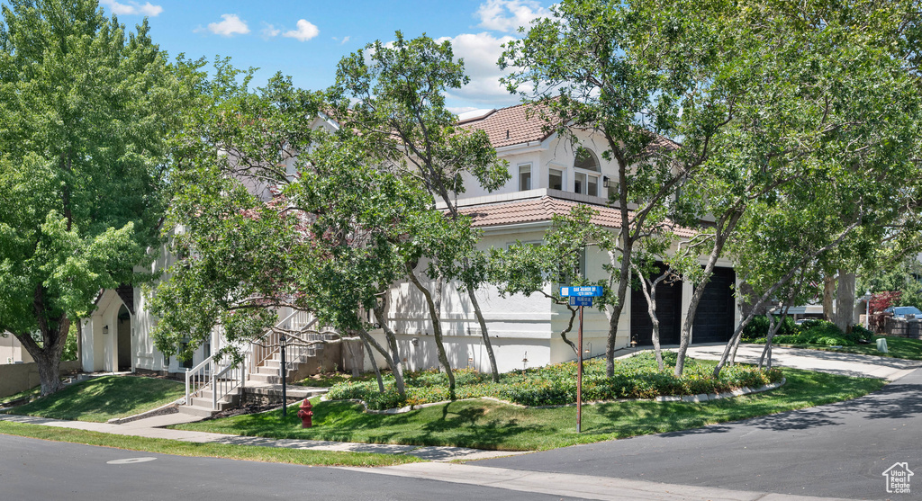 View of property featuring stairway and driveway