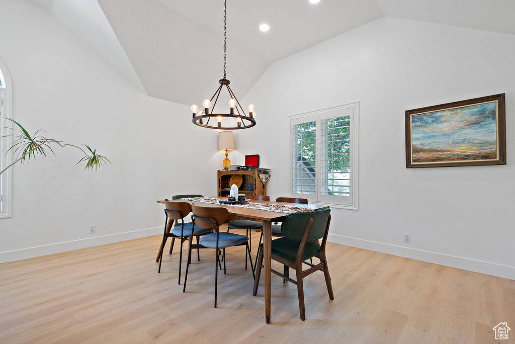 Dining room with vaulted ceiling, a chandelier, light wood-style floors, and recessed lighting