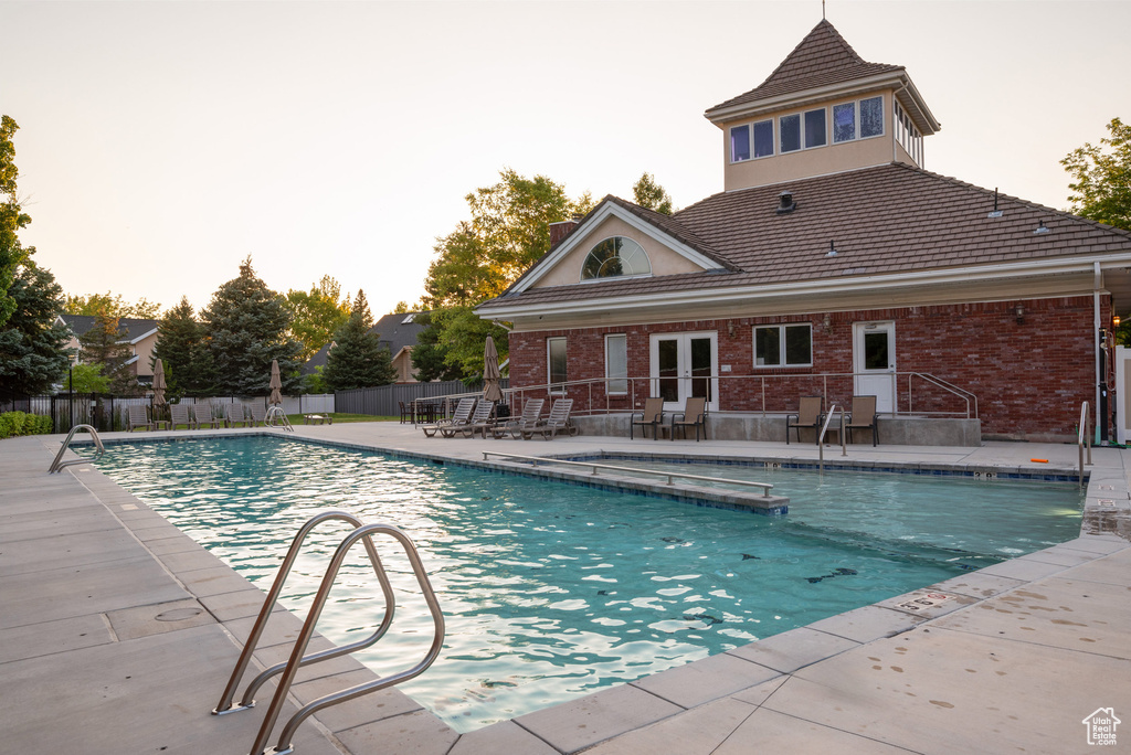View of pool with a patio, a pool with connected hot tub, and french doors