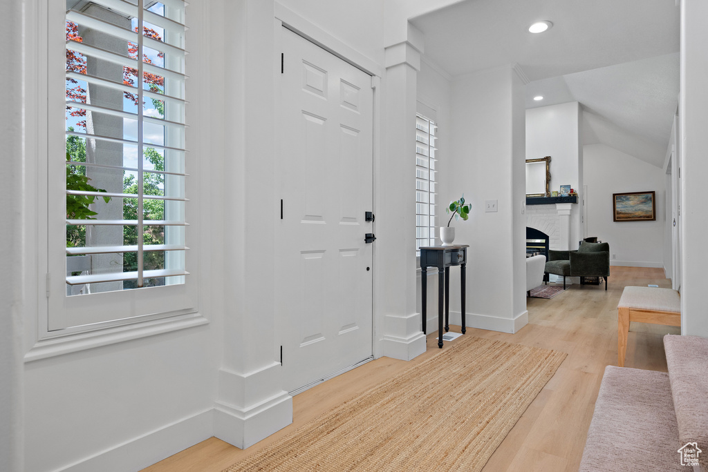 Entrance foyer with wood finished floors, recessed lighting, and a fireplace