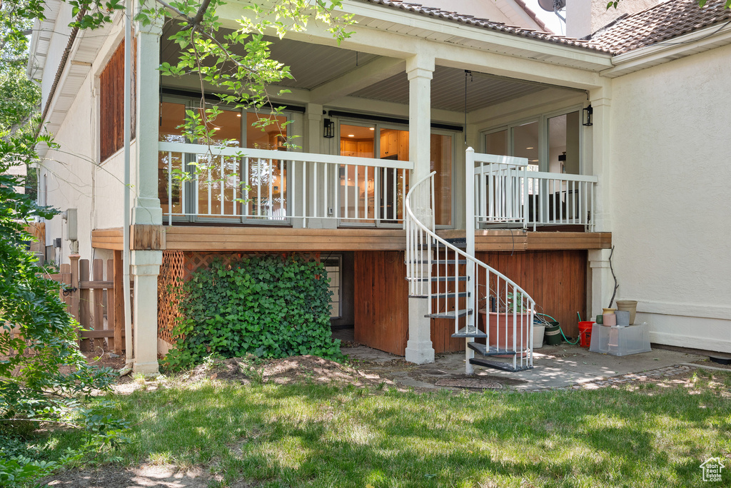 Back of house featuring stairs, a porch, and stucco siding