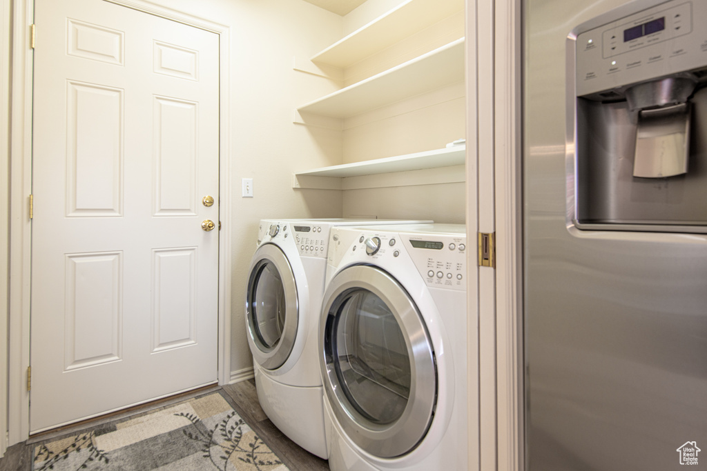Laundry room featuring washer and clothes dryer and wood finished floors