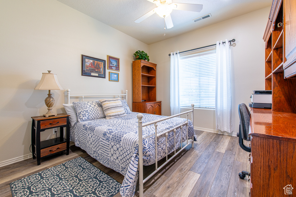 Bedroom featuring wood finished floors, a desk, and ceiling fan