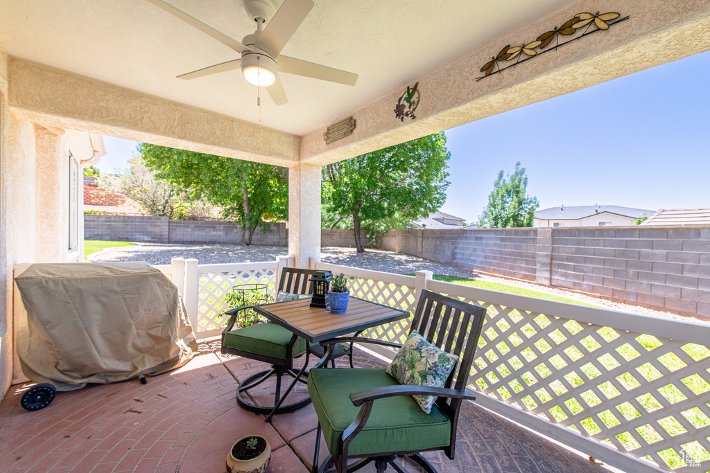 Wooden terrace with a ceiling fan and a fenced backyard