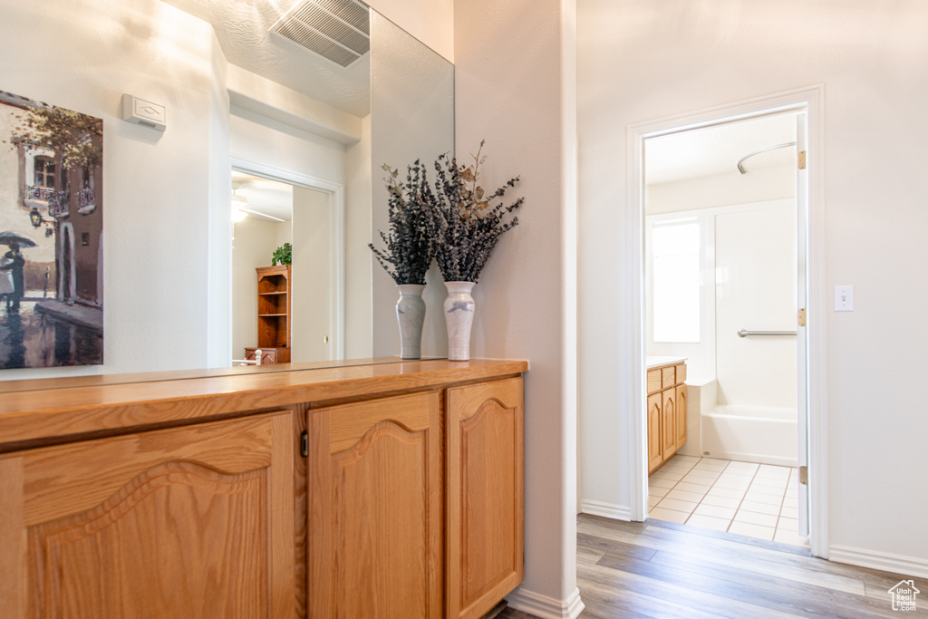 Bar featuring light wood-type flooring and baseboards