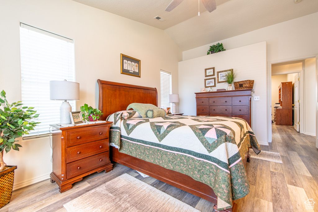 Bedroom featuring light wood-style floors, vaulted ceiling, and ceiling fan
