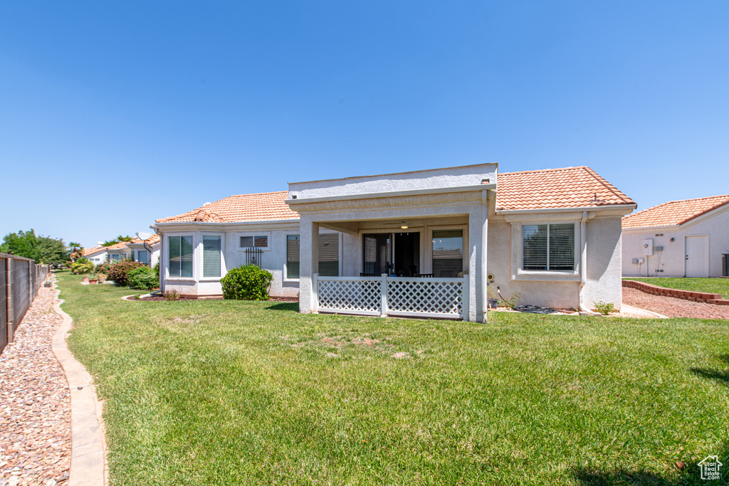 Back of property with stucco siding and a tile roof