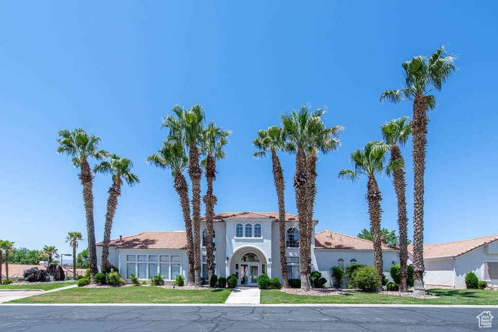 Mediterranean / spanish home with french doors, stucco siding, and a front lawn