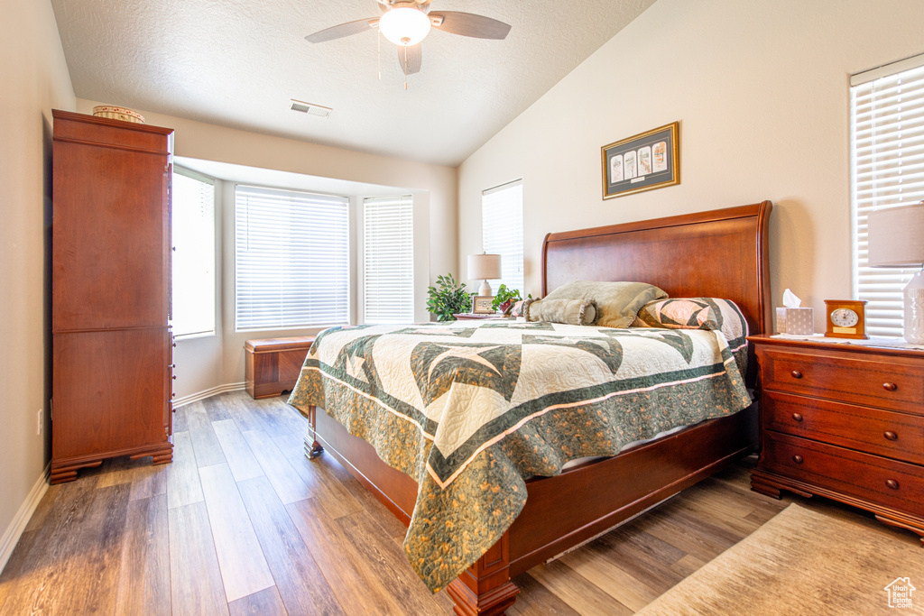 Bedroom featuring lofted ceiling, wood finished floors, and a ceiling fan