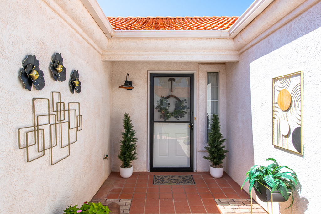 Entrance to property with stucco siding and a tiled roof