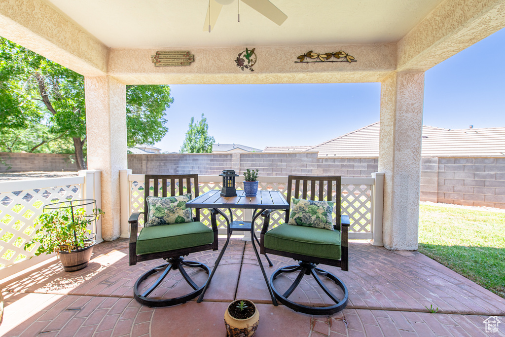 Fenced backyard with ceiling fan, a patio, and outdoor dining space