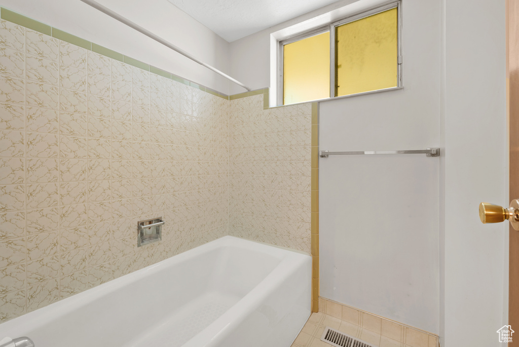 Full bathroom with tile patterned floors and shower / washtub combination