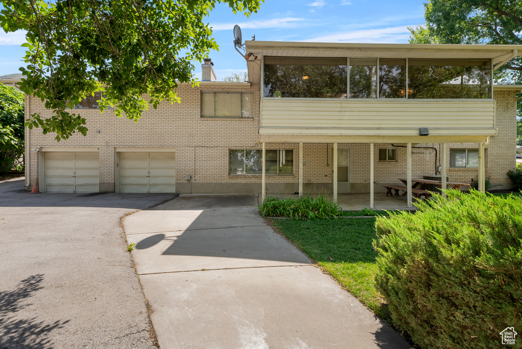 Townhome / multi-family property featuring asphalt driveway, brick siding, and an attached garage