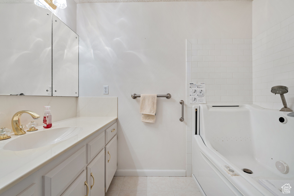 Full bathroom featuring vanity, a tub to relax in, and tile patterned flooring