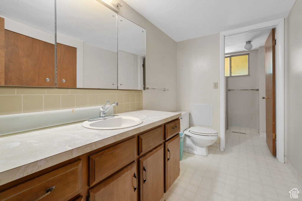 Bathroom with vanity, backsplash, and tile patterned floors