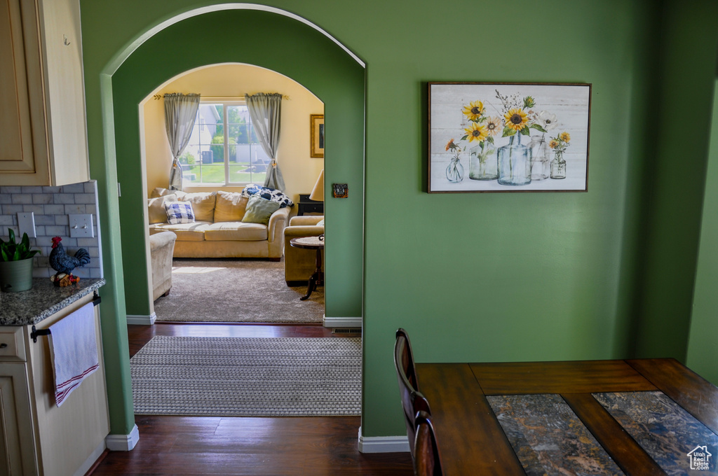 Dining area with dark wood-style floors and arched walkways
