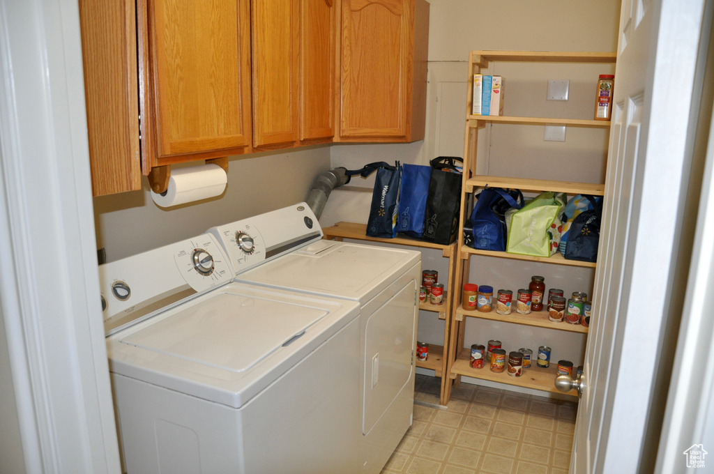 Laundry area with independent washer and dryer, cabinet space, and light floors