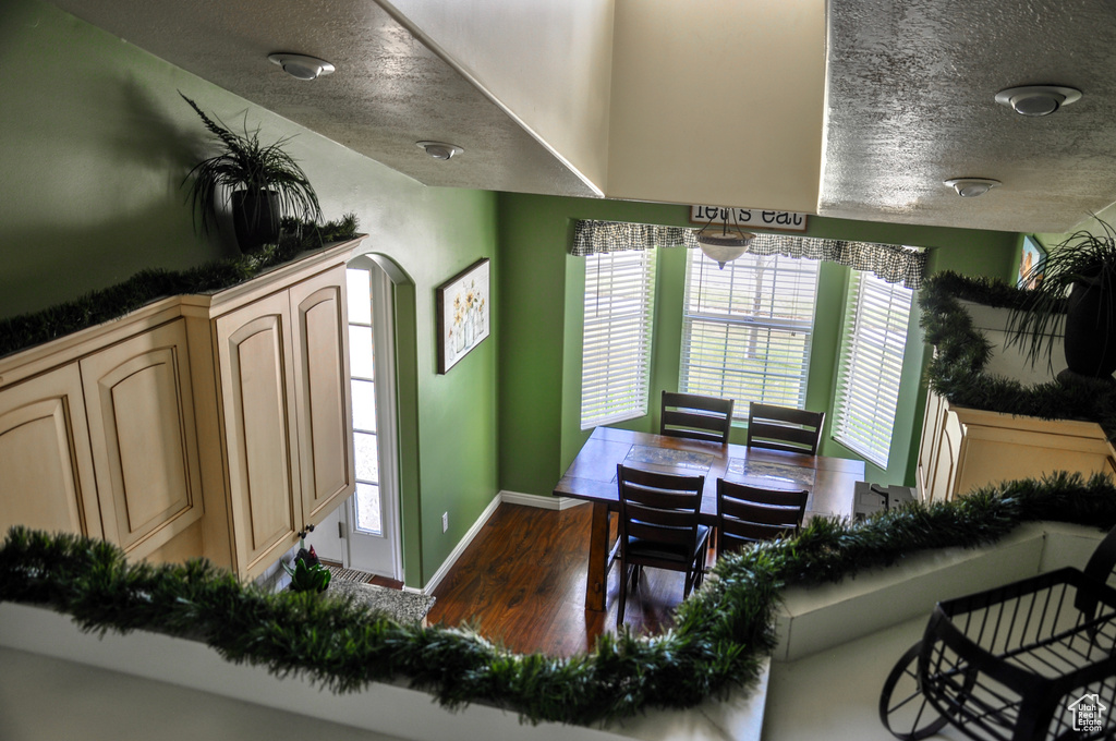 Dining area featuring dark wood-style floors, a textured ceiling, and arched walkways