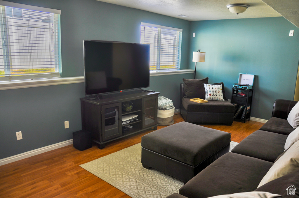 Living area with baseboards and wood finished floors