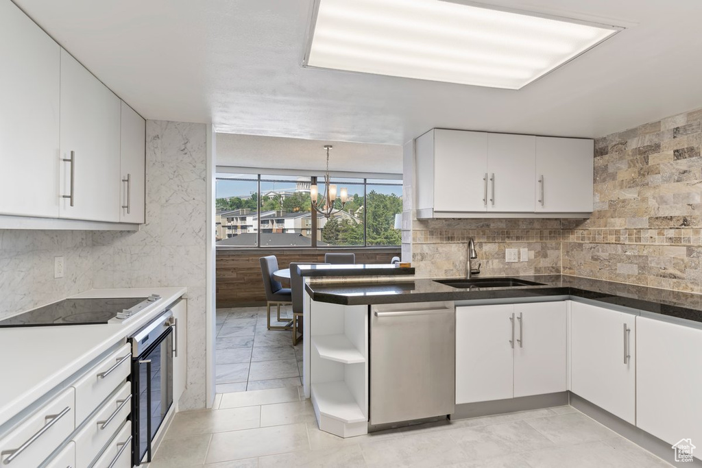 Kitchen featuring stainless steel dishwasher, black electric cooktop, wine cooler, white cabinets, and open shelves