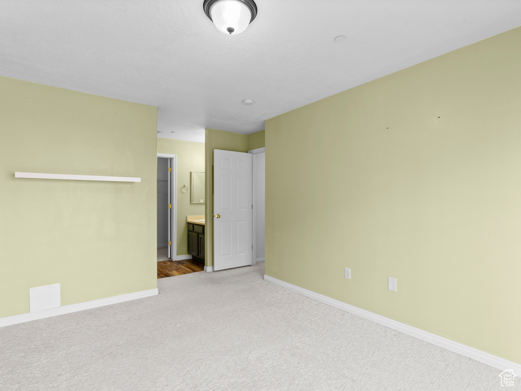 Carpeted spare room featuring baseboards