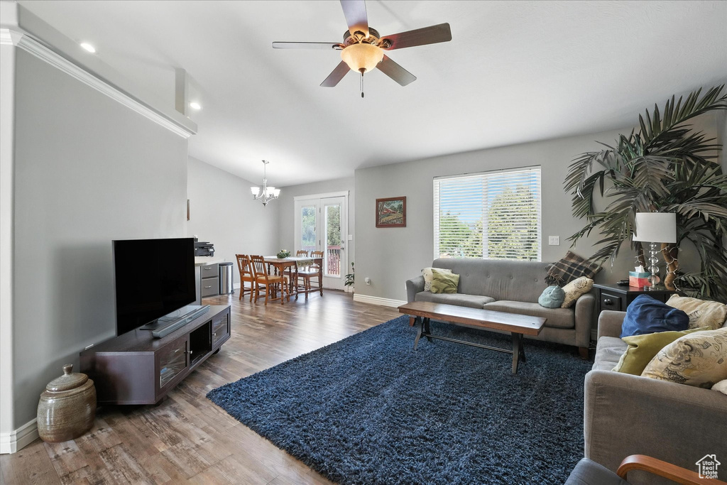Living room with a chandelier, light wood-style floors, vaulted ceiling, a ceiling fan, and recessed lighting