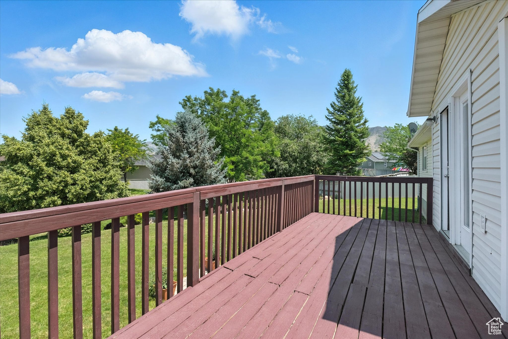 Wooden terrace featuring a yard