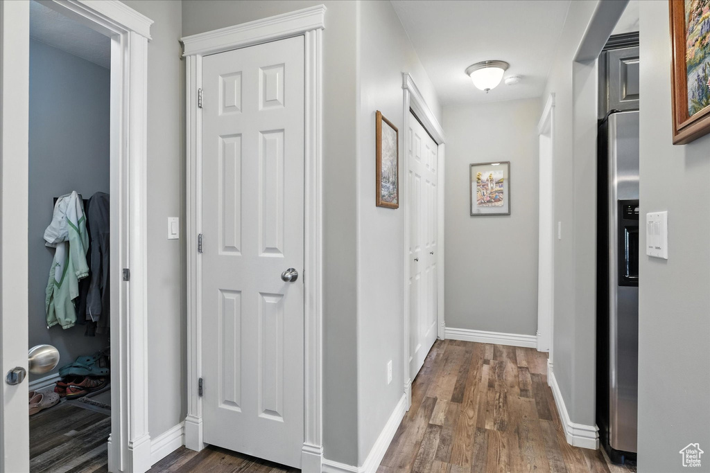 Corridor featuring dark wood finished floors and baseboards