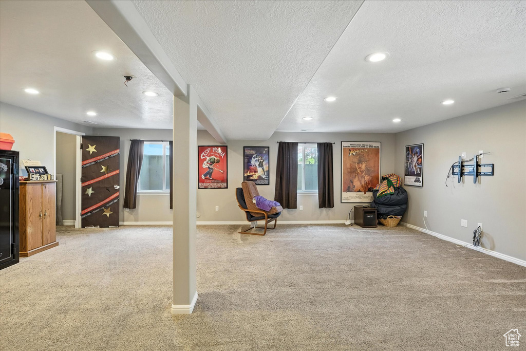 Living area with a textured ceiling, carpet floors, and recessed lighting