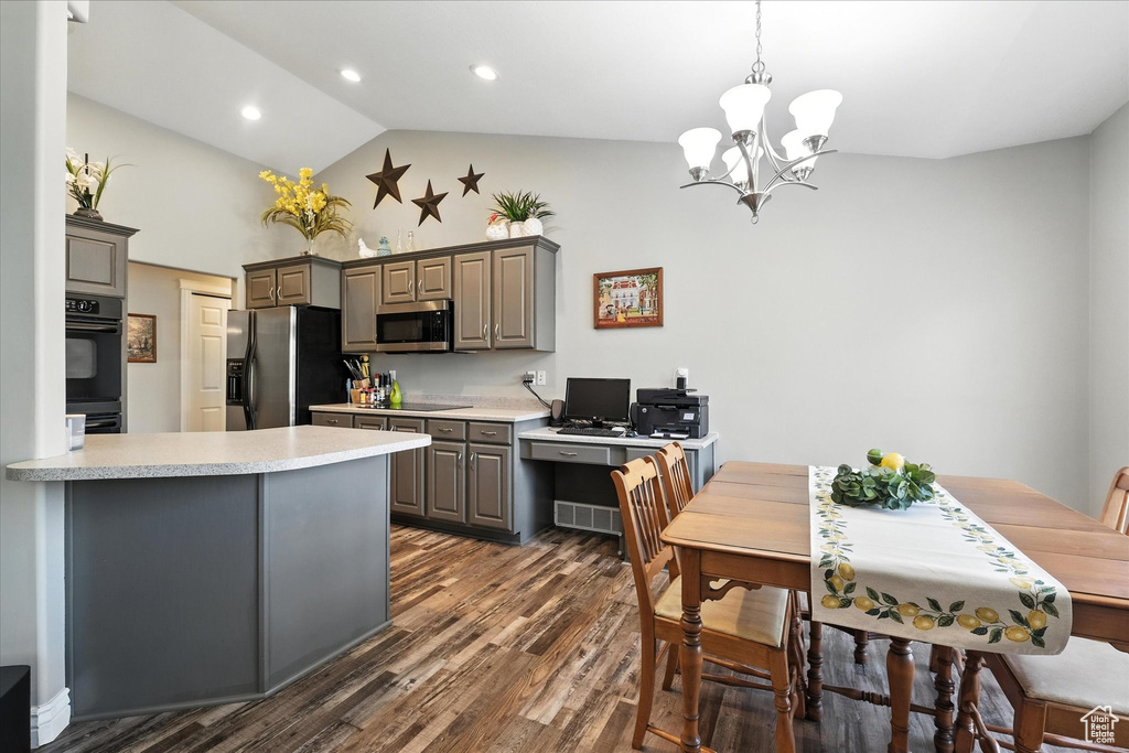 Kitchen featuring appliances with stainless steel finishes, gray cabinets, dark wood-type flooring, light countertops, and a chandelier
