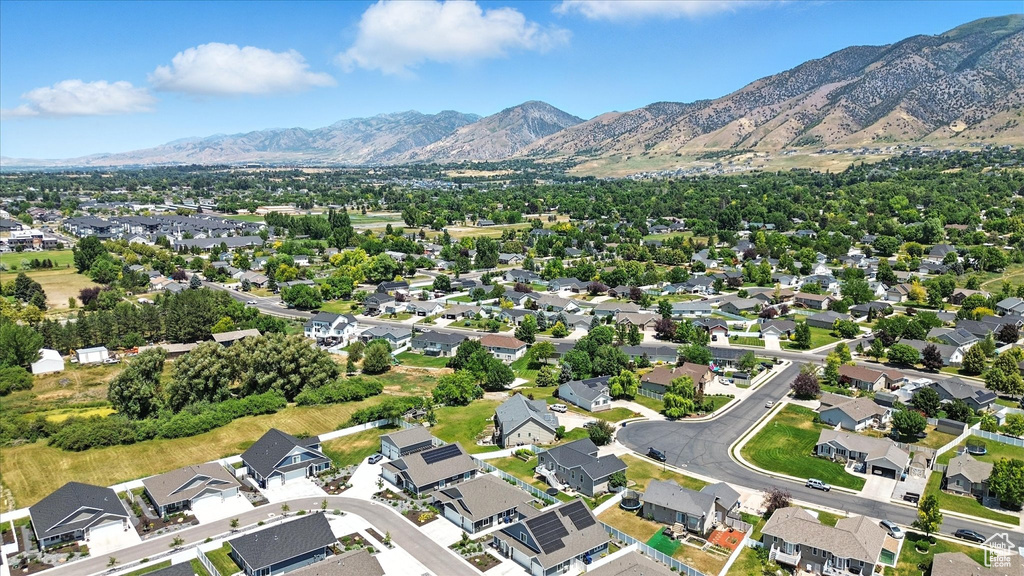 Aerial view of property and surrounding area with mountains and nearby suburban area