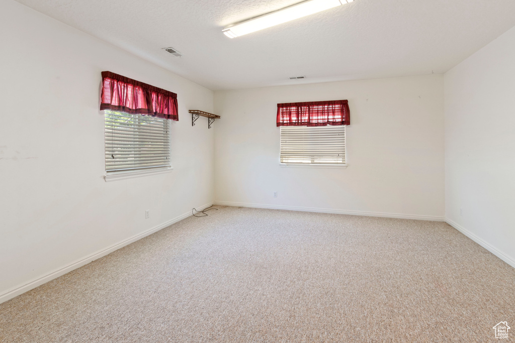 Carpeted spare room with baseboards