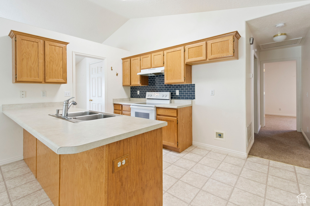 Kitchen featuring white range with electric cooktop, under cabinet range hood, light countertops, a peninsula, and tasteful backsplash