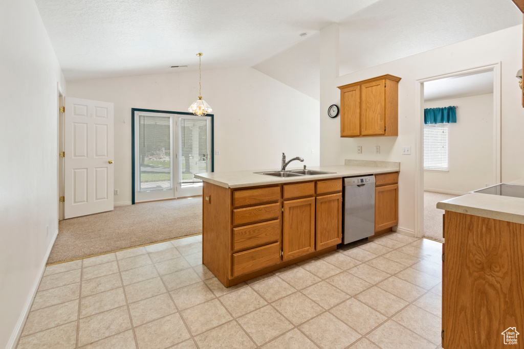 Kitchen featuring dishwasher, lofted ceiling, brown cabinetry, a peninsula, and light countertops