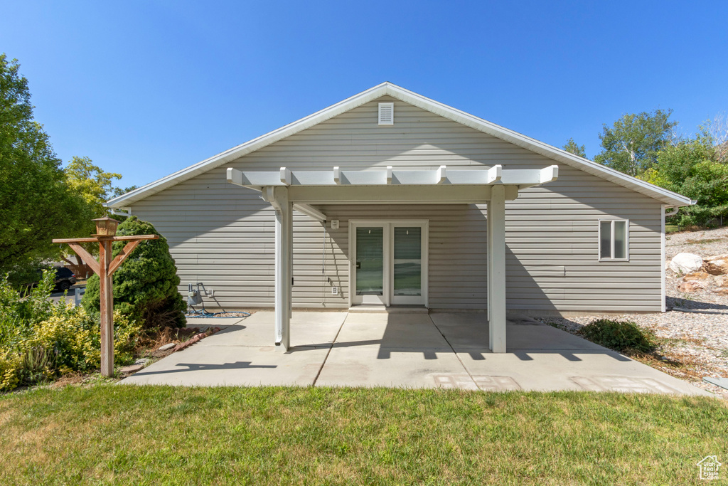 Back of property featuring a patio area, a yard, and a pergola