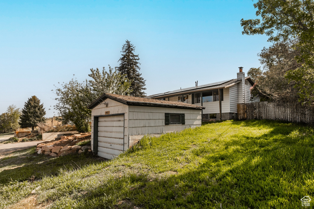 Back of property featuring a garage and an outbuilding