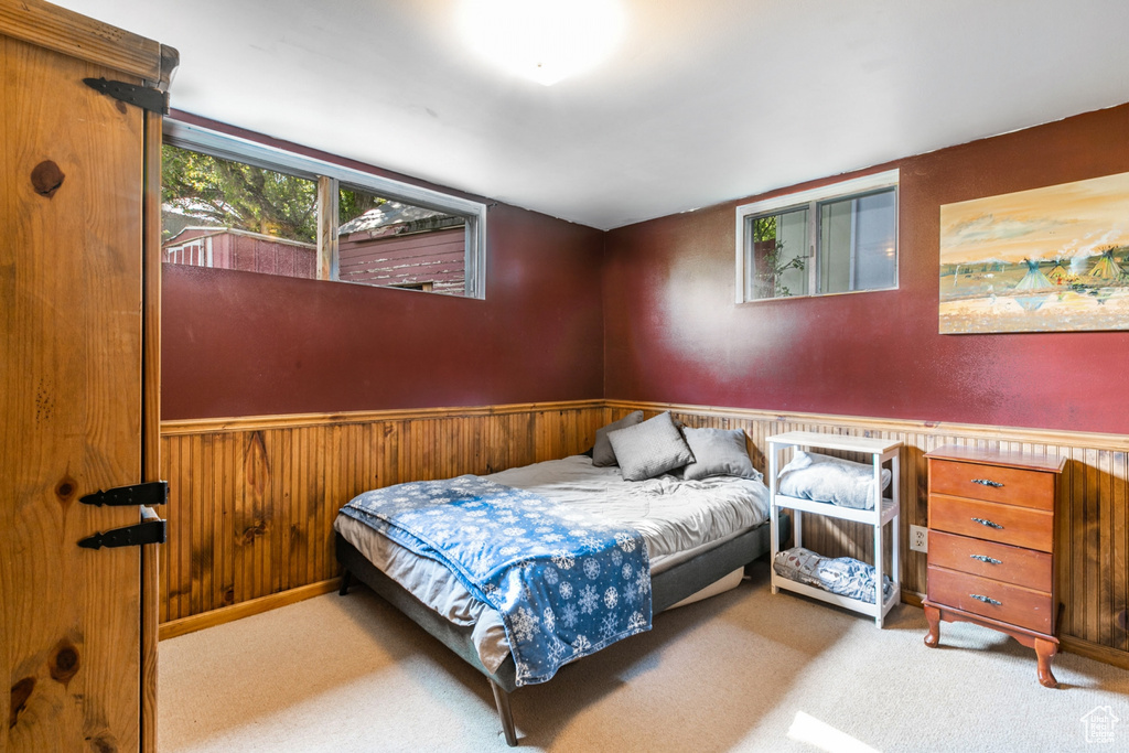 Bedroom featuring wainscoting, carpet floors, and wood walls