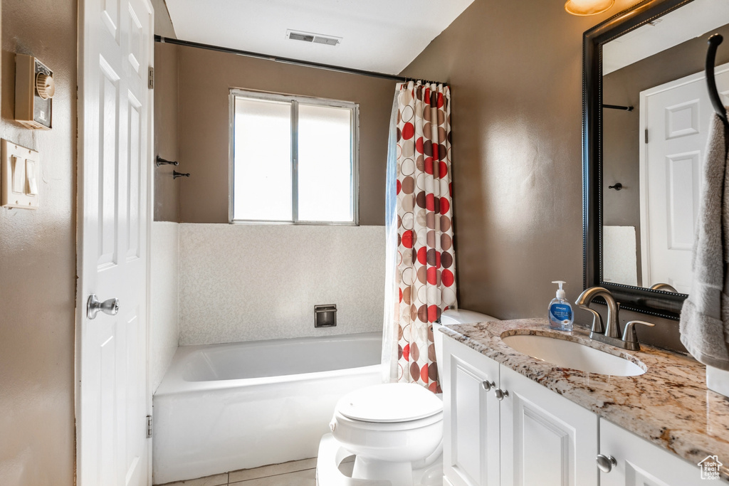 Bathroom with vanity, shower / bathtub combination with curtain, and tile patterned flooring