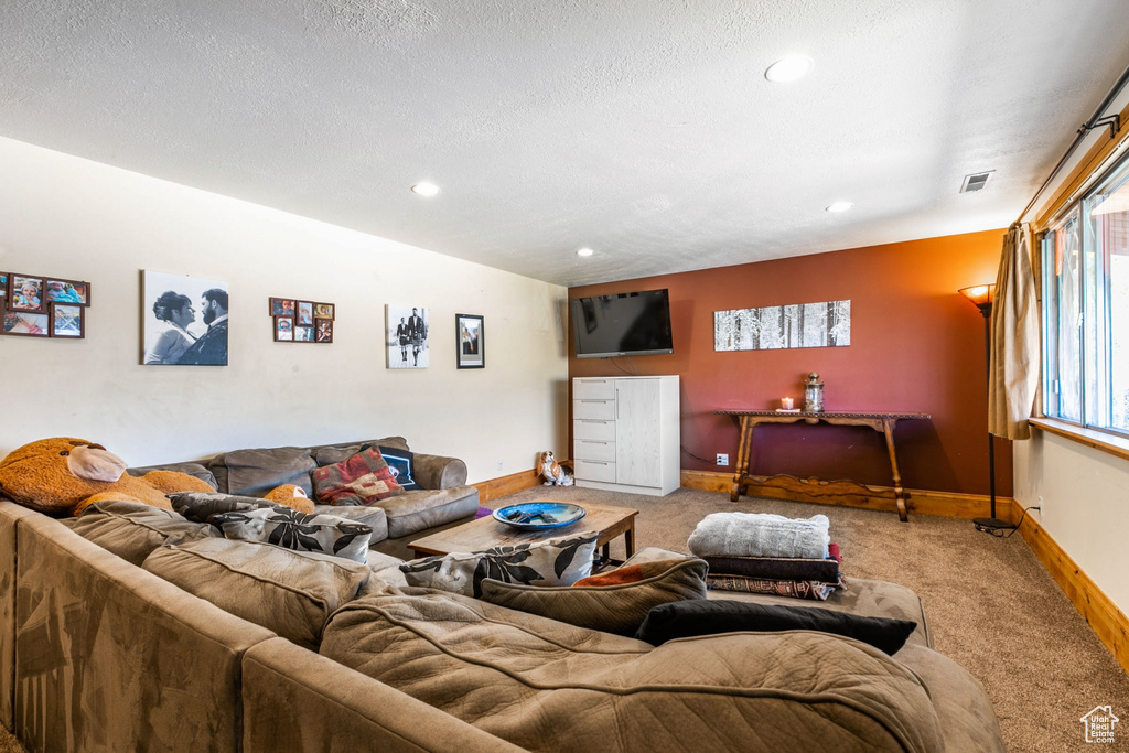 Living area featuring carpet floors, recessed lighting, and a textured ceiling