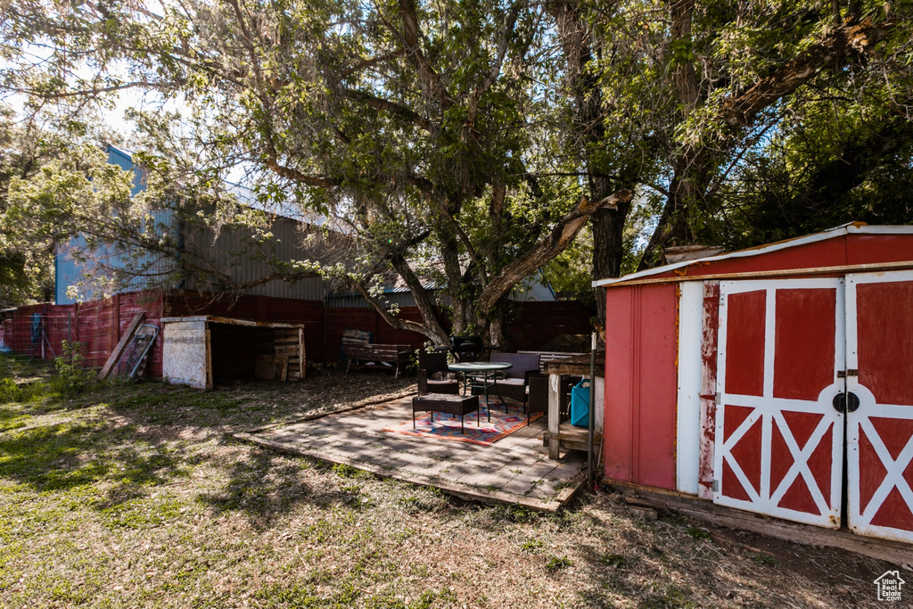 View of yard with a storage unit and a patio area