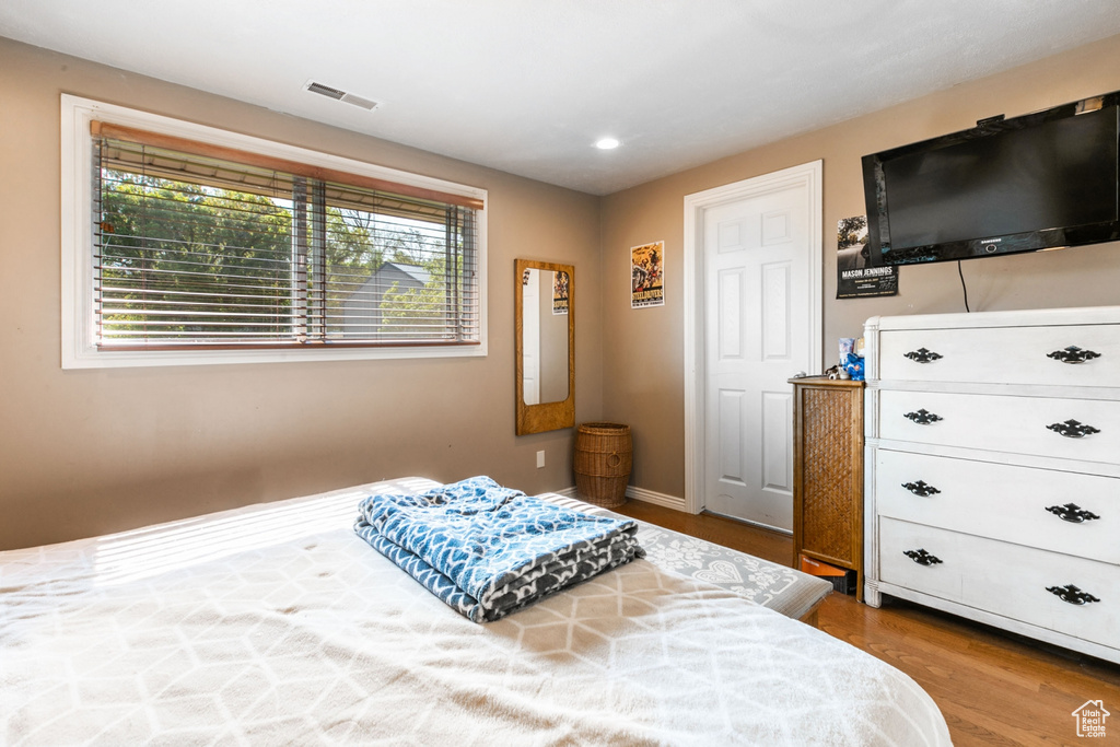 Bedroom featuring multiple windows, wood finished floors, and recessed lighting