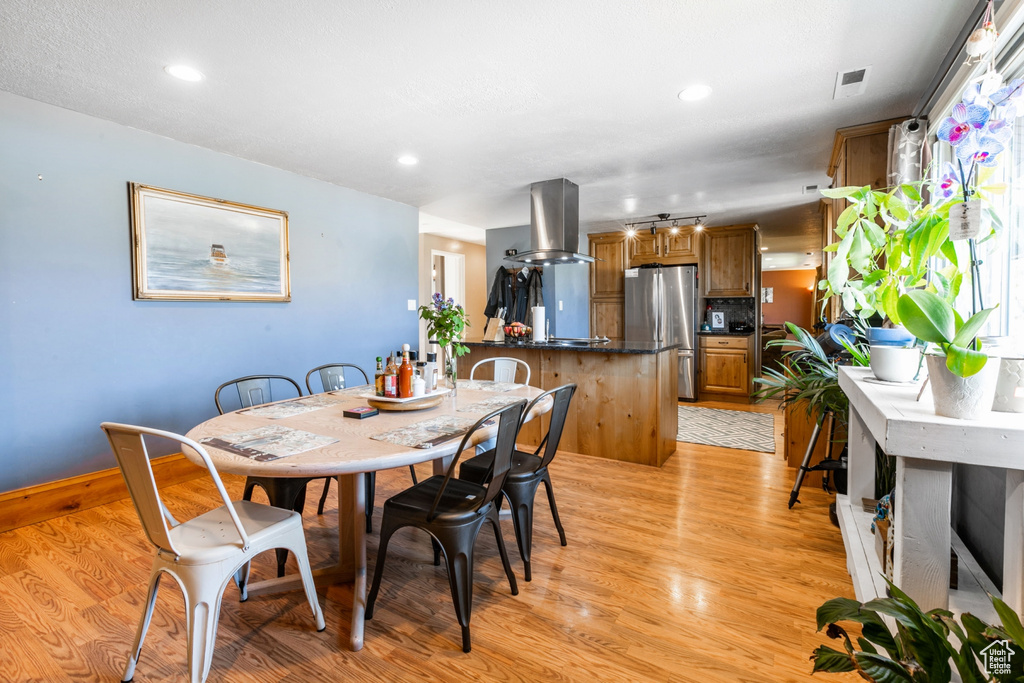 Dining room with light wood-style floors and recessed lighting
