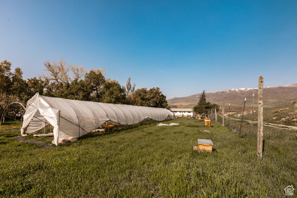 View of yard with a mountain view, an outbuilding, and a greenhouse