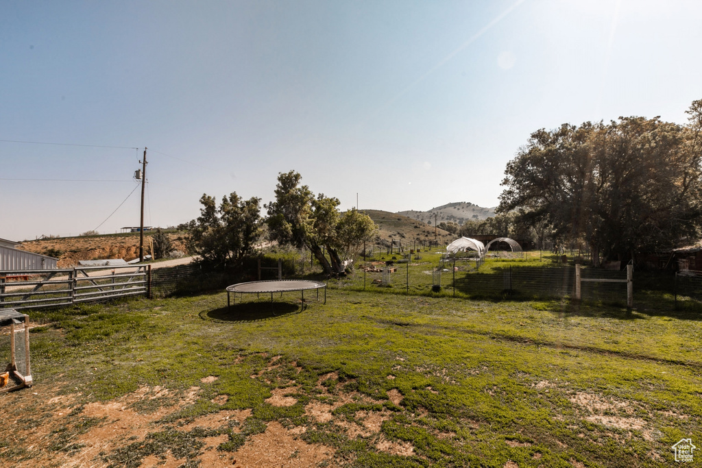 View of yard with a trampoline, a mountain view, and a rural view