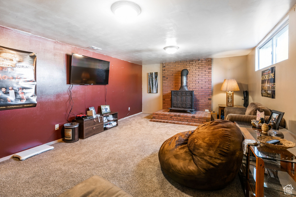 Carpeted living room featuring a wood stove and baseboards